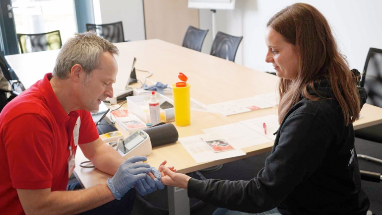 An Arvato employee during a stroke risk check with the health advisor